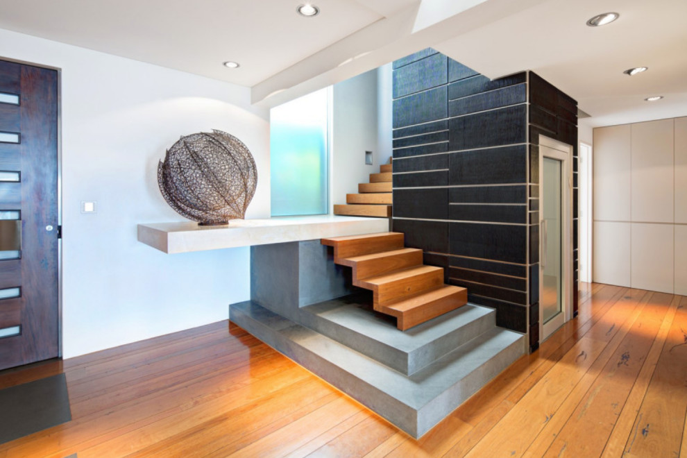 Large contemporary wood l-shaped staircase in Sydney with wood risers.