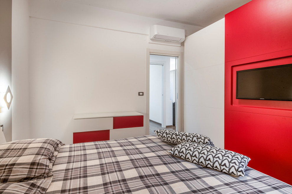 Foto di una camera da letto minimal di medie dimensioni con pareti arancioni, parquet chiaro, camino classico, cornice del camino in intonaco e pavimento marrone