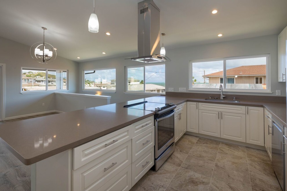 Design ideas for a mid-sized beach style u-shaped open plan kitchen in Hawaii with an undermount sink, shaker cabinets, white cabinets, granite benchtops, stainless steel appliances, ceramic floors, a peninsula and beige floor.