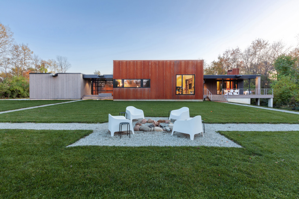 Idées déco pour une façade de maison métallique et orange moderne de plain-pied et de taille moyenne avec un toit en appentis, un toit en métal et un toit gris.