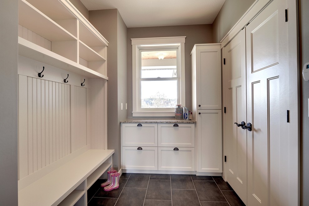 Photo of a country mudroom in Minneapolis with brown walls and brown floor.