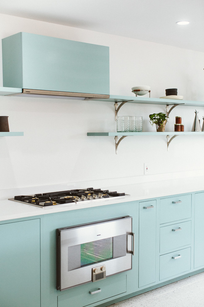 This is an example of a modern single-wall eat-in kitchen in Austin with an undermount sink, flat-panel cabinets, blue cabinets, quartz benchtops, white splashback, engineered quartz splashback, stainless steel appliances, terrazzo floors, with island, white floor, white benchtop and recessed.