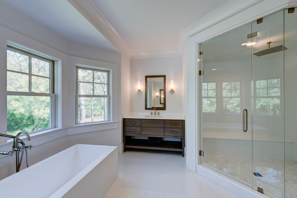 Freestanding bathtub - large transitional master white tile and ceramic tile porcelain tile freestanding bathtub idea with a two-piece toilet, white walls, a drop-in sink, quartzite countertops, flat-panel cabinets and medium tone wood cabinets