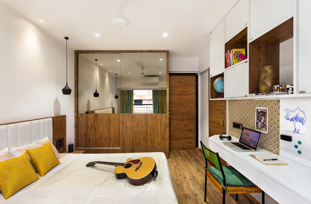 Design ideas for a contemporary gender-neutral kids' room in Mumbai with white walls, medium hardwood floors and brown floor.