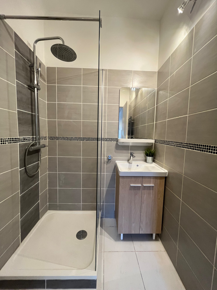 Exemple d'une petite salle d'eau grise et blanche tendance avec une douche d'angle, un carrelage gris, des carreaux de céramique, un mur gris, un sol en carrelage de céramique, une grande vasque, un sol beige, meuble simple vasque et meuble-lavabo sur pied.