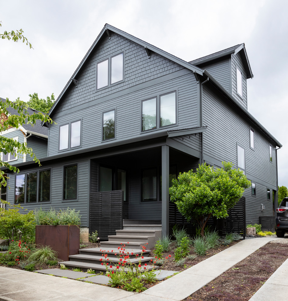Photo of a large modern three-storey grey house exterior in Portland with wood siding, a gable roof and a shingle roof.
