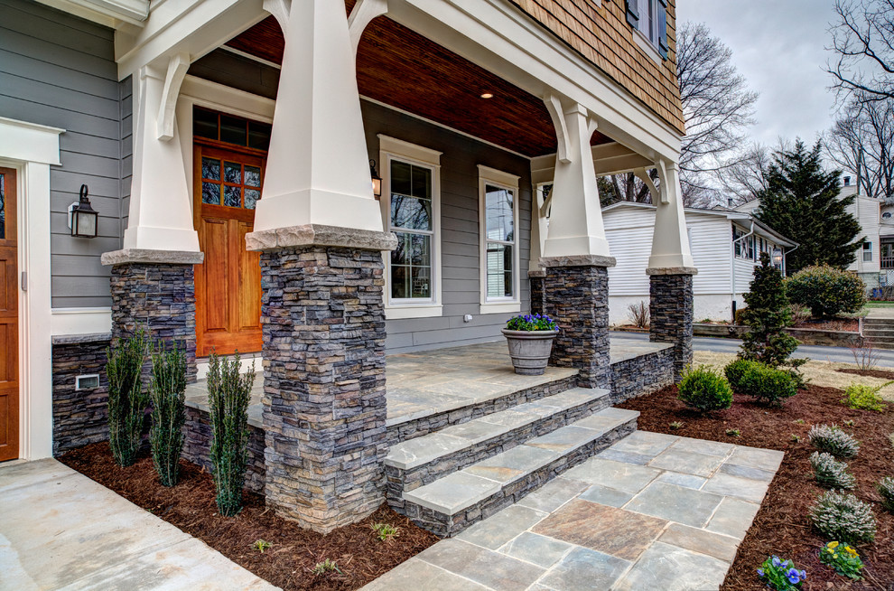 Inspiration for a mid-sized arts and crafts front yard verandah in DC Metro with a roof extension, a container garden and natural stone pavers.
