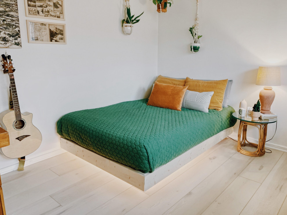 Ejemplo de dormitorio tipo loft retro de tamaño medio con paredes blancas, suelo vinílico, suelo beige y vigas vistas