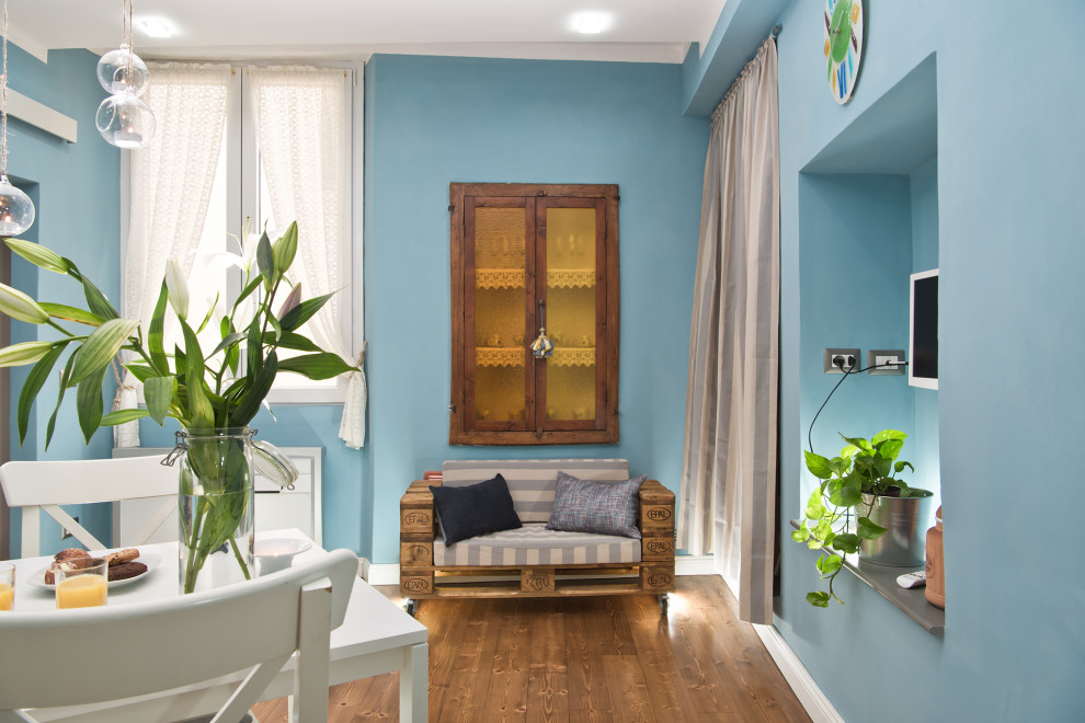 Small contemporary kitchen/dining combo in Florence with blue walls, light hardwood floors and brown floor.