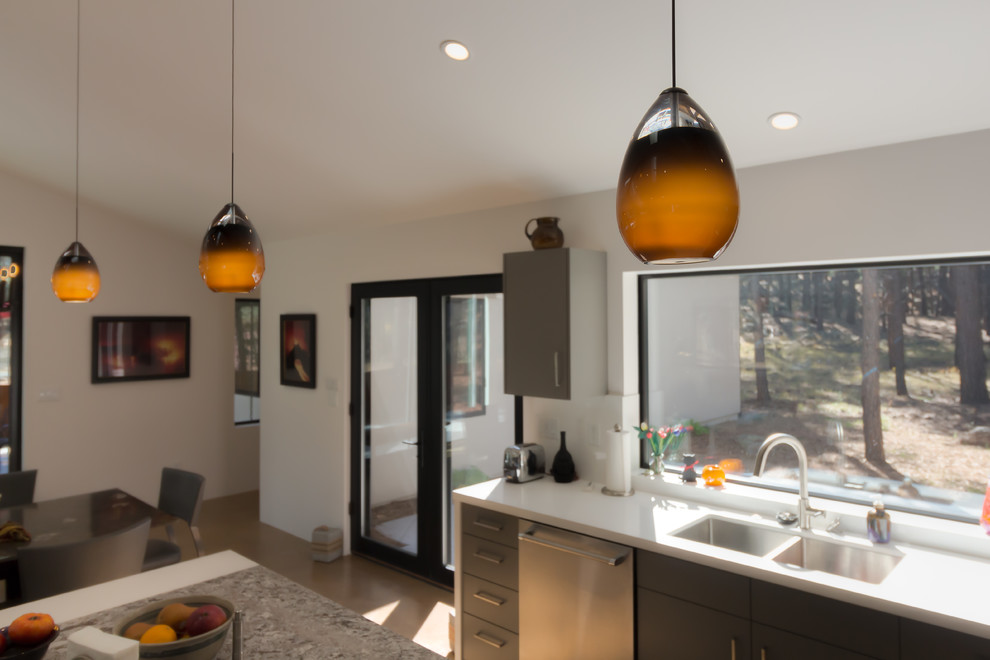 Large transitional u-shaped medium tone wood floor and brown floor open concept kitchen photo in Phoenix with an undermount sink, flat-panel cabinets, gray cabinets, solid surface countertops, white backsplash, stainless steel appliances and an island