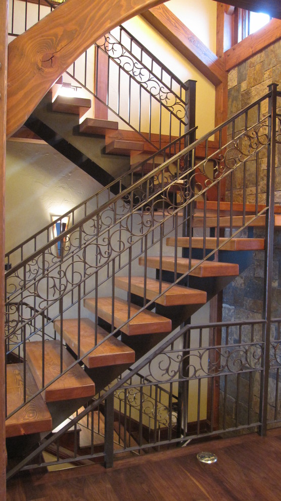 Example of a large mountain style wooden straight metal railing staircase design with metal risers