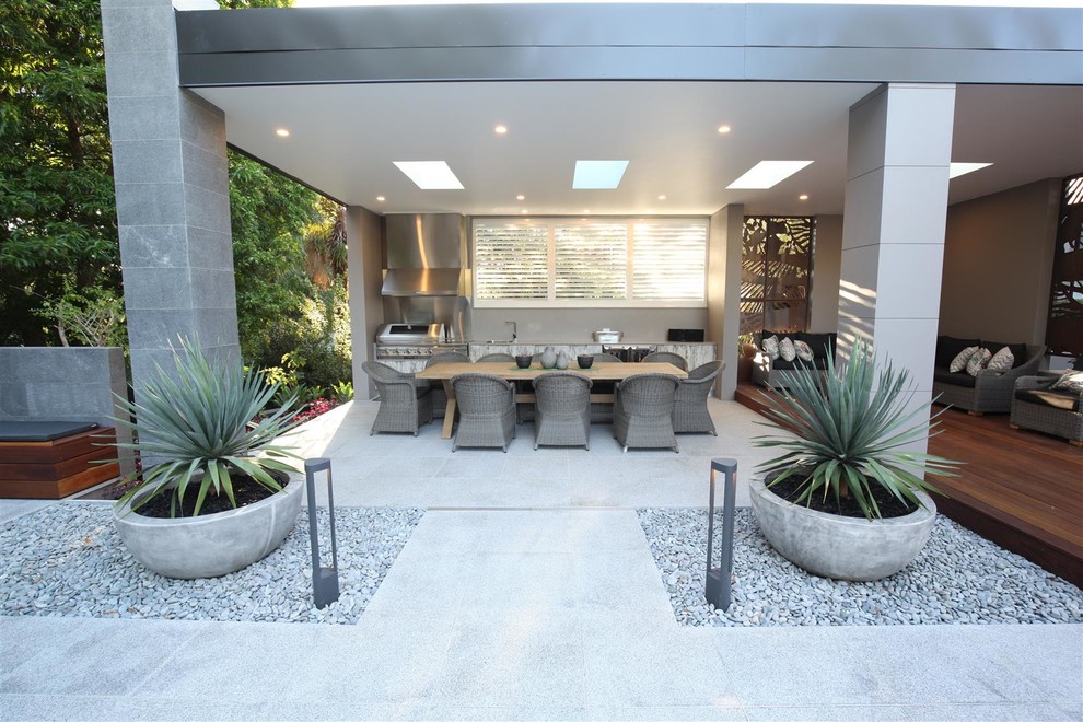Inspiration pour une grande terrasse arrière design avec un foyer extérieur, une dalle de béton et aucune couverture.