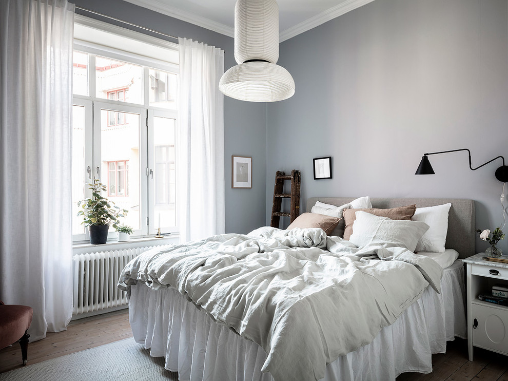 This is an example of a mid-sized scandinavian guest bedroom in Gothenburg with grey walls, medium hardwood floors and beige floor.