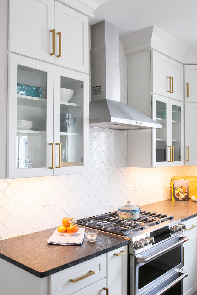 Kitchen pantry - large transitional l-shaped brown floor kitchen pantry idea in Baltimore with a drop-in sink, shaker cabinets, white cabinets, quartz countertops, white backsplash, ceramic backsplash, stainless steel appliances, an island and white countertops
