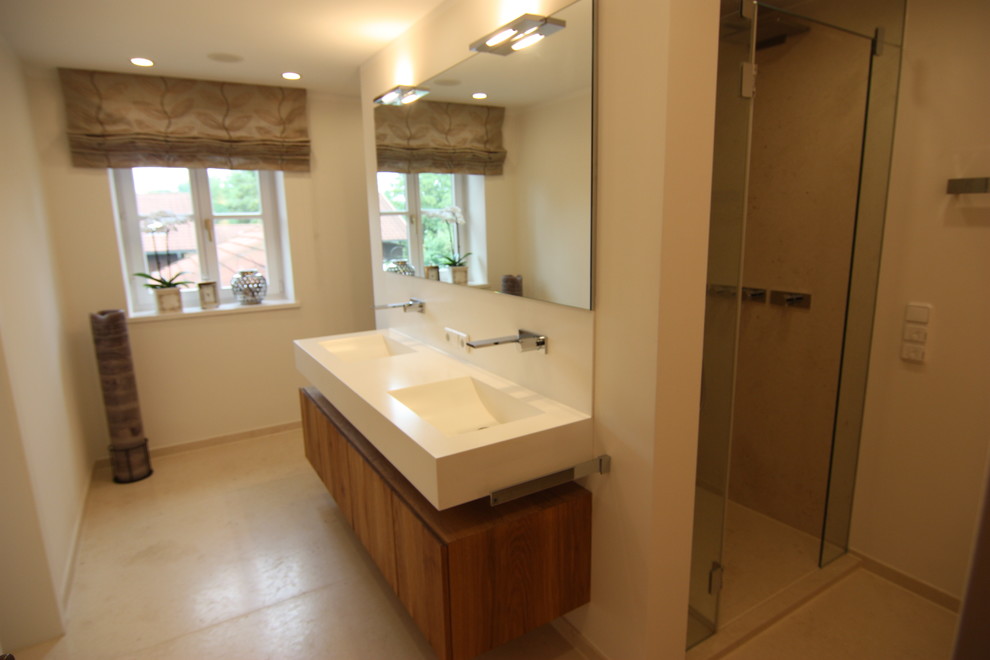 Mid-sized contemporary master bathroom in Munich with flat-panel cabinets, brown cabinets, a curbless shower, yellow tile, stone tile, white walls, limestone floors, a drop-in sink, solid surface benchtops, beige floor and white benchtops.