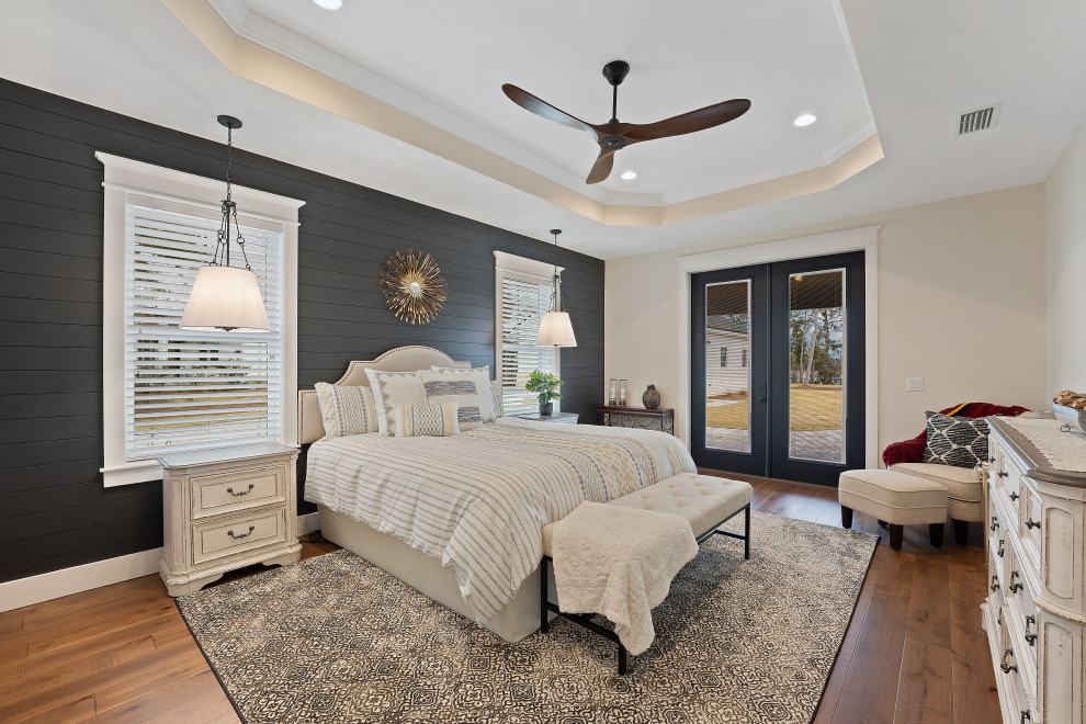 Photo of a large country master bedroom in Other with beige walls, medium hardwood floors, brown floor, recessed and planked wall panelling.