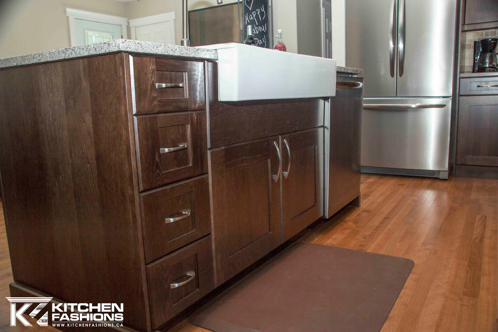 Example of a large transitional u-shaped medium tone wood floor open concept kitchen design with a farmhouse sink, shaker cabinets, dark wood cabinets, quartz countertops, brown backsplash, stone tile backsplash, stainless steel appliances and an island