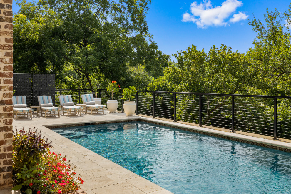 Foto de piscina minimalista grande rectangular en patio trasero con privacidad y adoquines de piedra natural