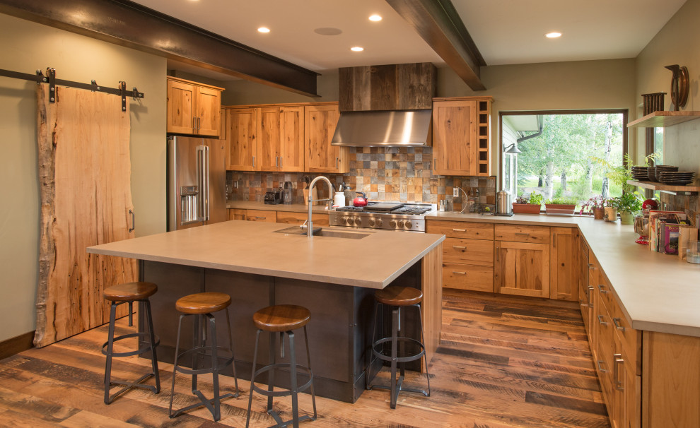Kitchen - rustic u-shaped dark wood floor and brown floor kitchen idea with an undermount sink, shaker cabinets, medium tone wood cabinets, brown backsplash, stainless steel appliances, an island and gray countertops