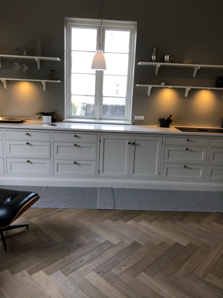 Photo of a mid-sized scandinavian galley eat-in kitchen in Copenhagen with a double-bowl sink, shaker cabinets, grey cabinets, marble benchtops, coloured appliances, dark hardwood floors, multi-coloured floor, beige benchtop and vaulted.