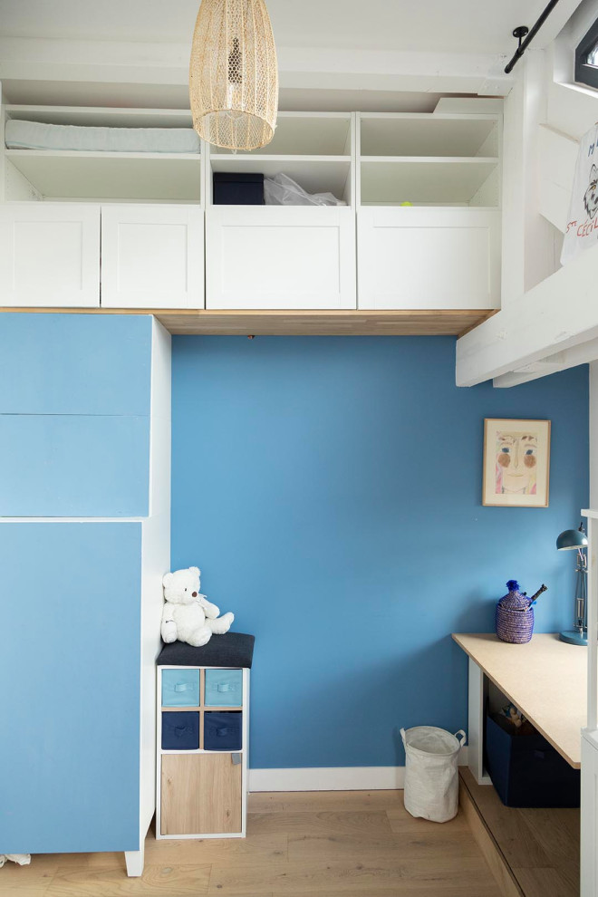 Exemple d'une chambre d'enfant de taille moyenne avec un mur bleu, parquet clair et un sol beige.
