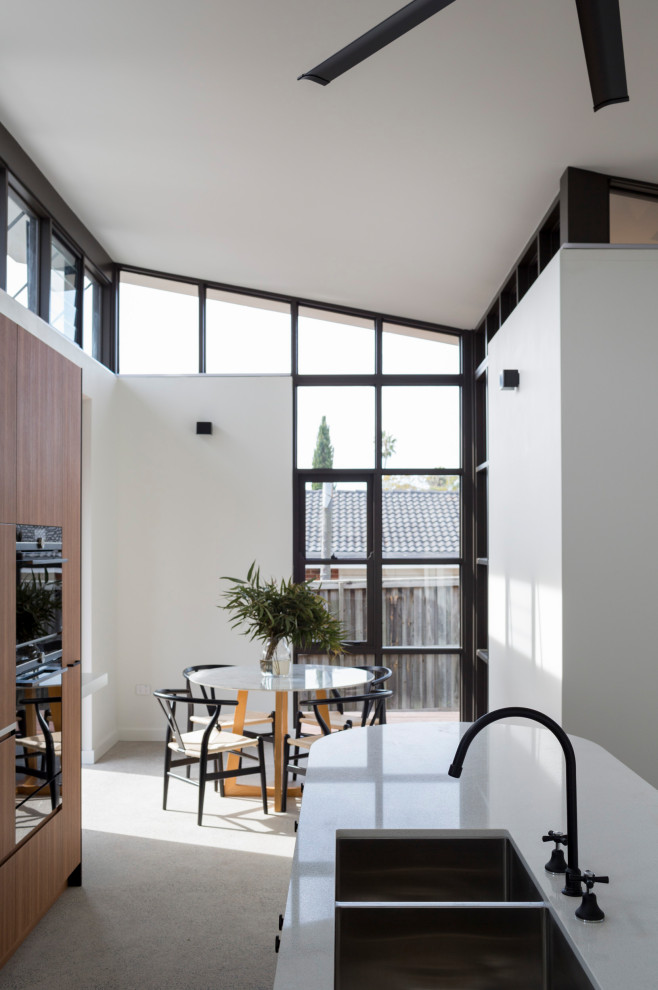 Photo of a mid-sized contemporary kitchen/dining combo in Sydney with white walls, concrete floors and grey floor.