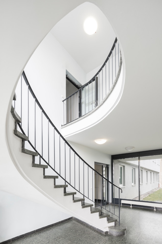 This is an example of a large contemporary marble spiral staircase in Hanover with marble risers and metal railing.