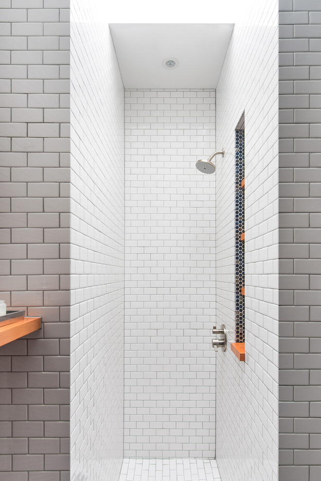 Modern bathroom in New York with a curbless shower, white tile and subway tile.
