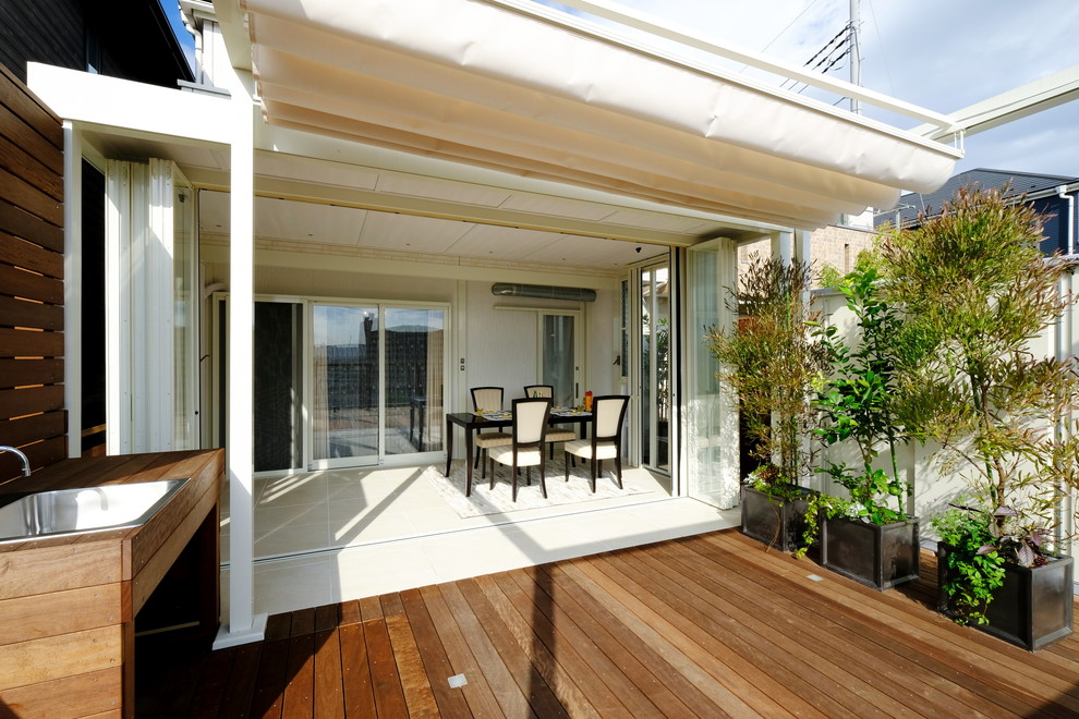 Foto de terraza tradicional en patio lateral con cocina exterior y toldo