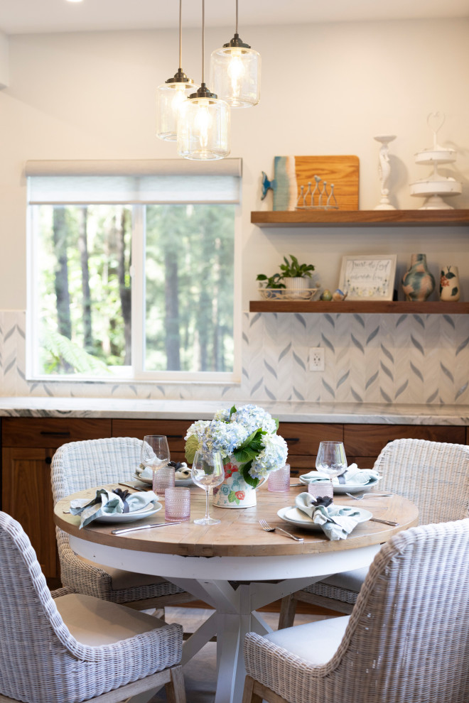 Exempel på ett mellanstort maritimt kök och matrum, med en enkel diskho, skåp i shakerstil, skåp i mellenmörkt trä, bänkskiva i kvartsit, blått stänkskydd, stänkskydd i mosaik, svarta vitvaror och skiffergolv
