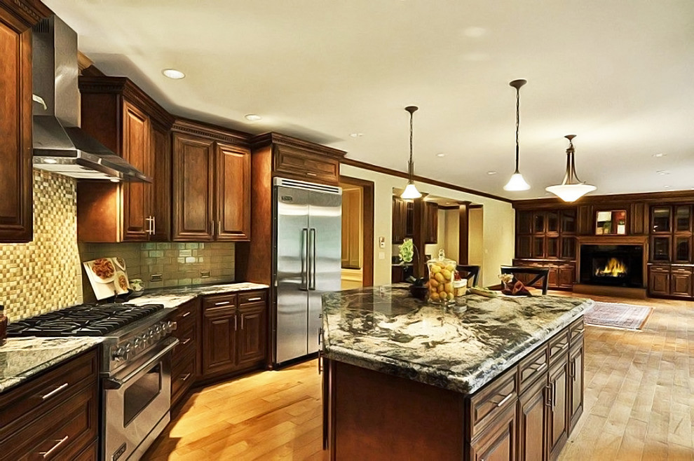 Example of a transitional l-shaped light wood floor kitchen design in Cincinnati with raised-panel cabinets, dark wood cabinets, granite countertops, beige backsplash, stainless steel appliances and an island
