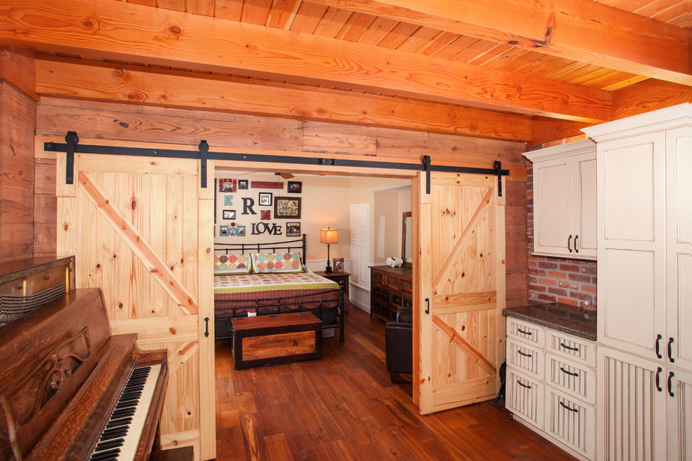 Mid-sized mountain style medium tone wood floor bedroom photo in Austin with beige walls
