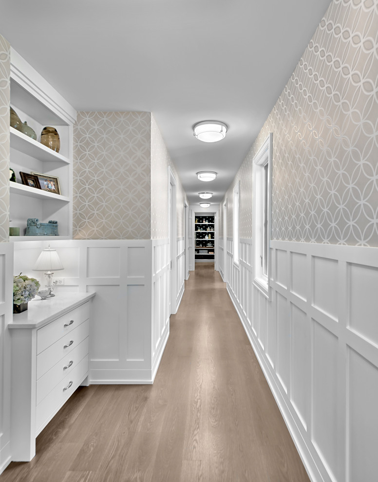 This is an example of an expansive transitional hallway in Grand Rapids with beige walls, medium hardwood floors, brown floor and wallpaper.