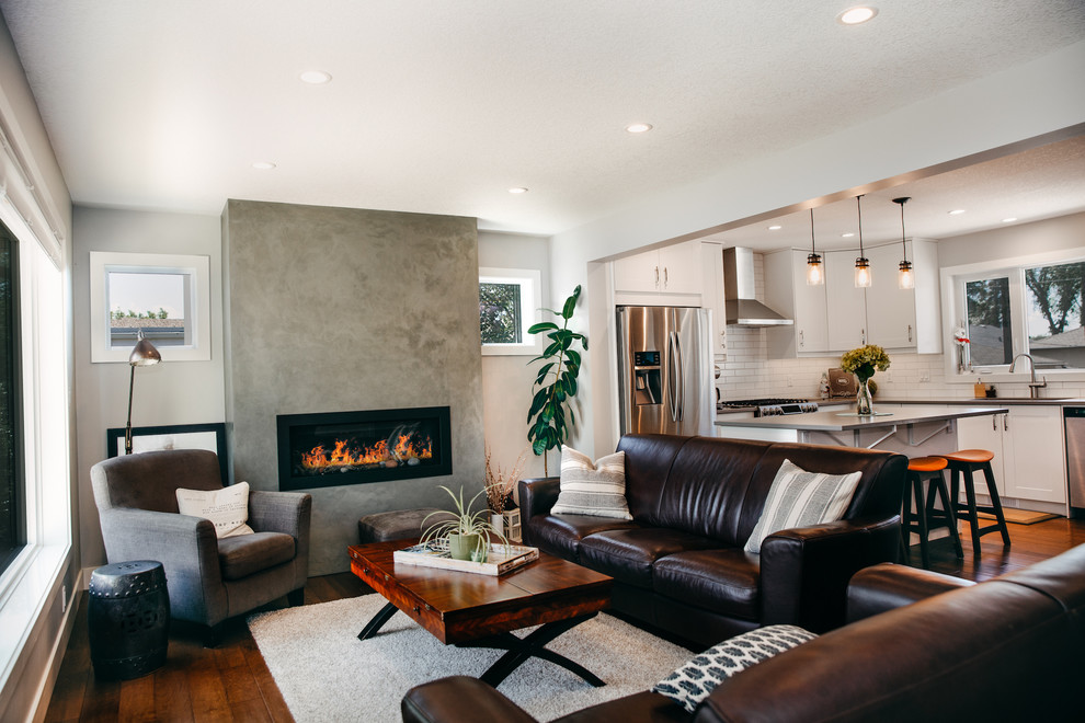 Mid-sized modern formal open concept living room in Edmonton with white walls, medium hardwood floors, a standard fireplace and brown floor.