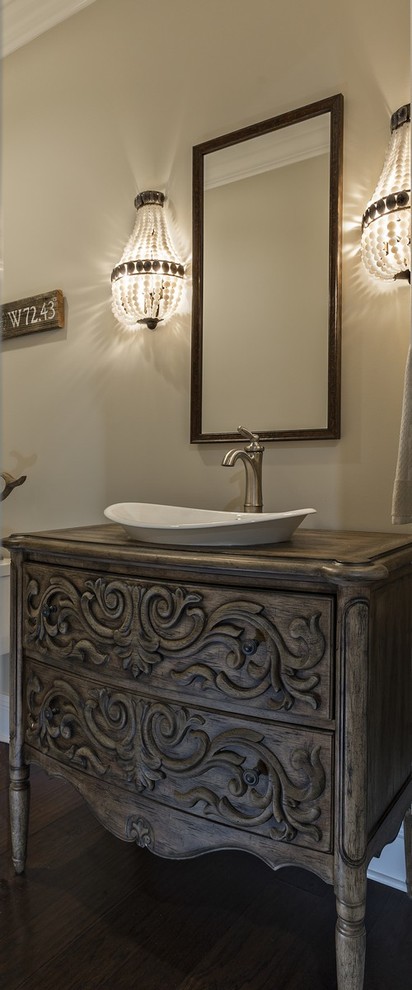 Photo of a traditional powder room in Miami with furniture-like cabinets, medium wood cabinets, beige walls, dark hardwood floors and a vessel sink.