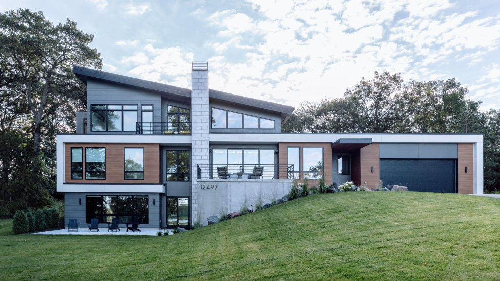 Großes, Dreistöckiges Modernes Einfamilienhaus mit Mix-Fassade, schwarzer Fassadenfarbe, Pultdach, Misch-Dachdeckung, schwarzem Dach und Verschalung in Minneapolis