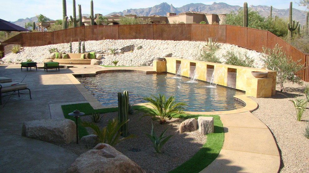 Mid-sized backyard custom-shaped natural pool in Phoenix with a hot tub and concrete slab.