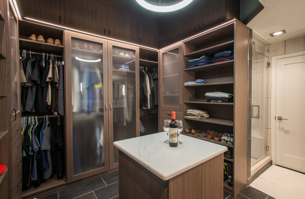Photo of a mid-sized modern men's walk-in wardrobe in Denver with flat-panel cabinets, medium wood cabinets, ceramic floors, grey floor and vaulted.