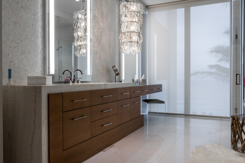 Photo of a large contemporary master bathroom in Miami with flat-panel cabinets, medium wood cabinets, a freestanding tub, a curbless shower, an undermount sink, granite benchtops, gray tile, mosaic tile, grey walls, marble floors and grey floor.
