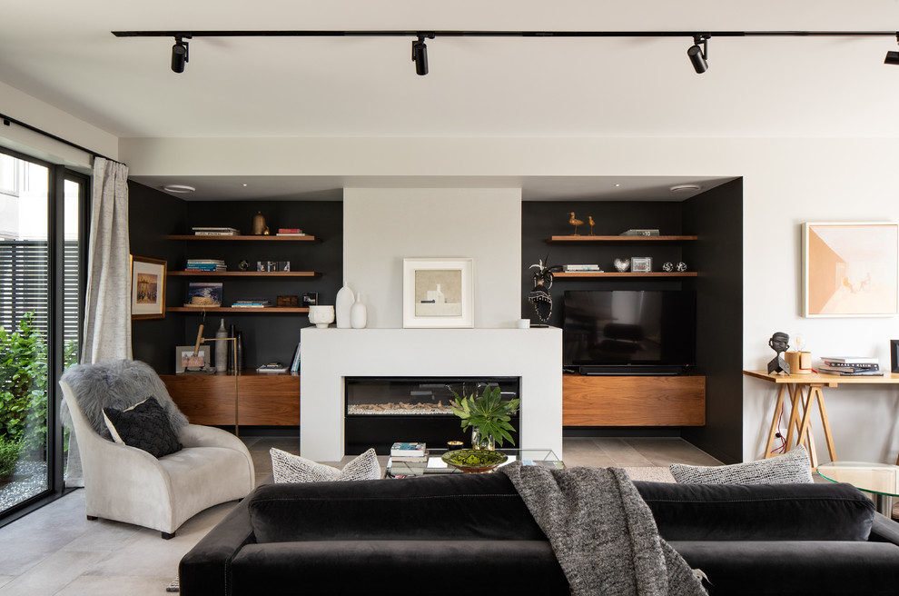 Contemporary open concept family room in Christchurch with black walls, a ribbon fireplace, a built-in media wall and grey floor.