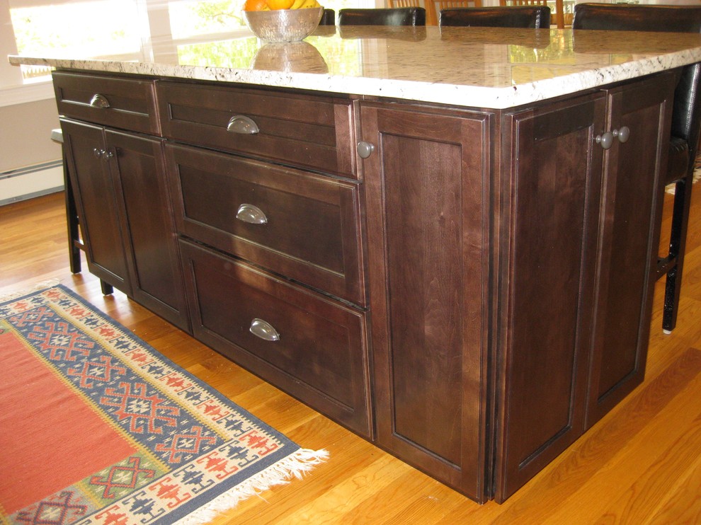 Transitional l-shaped medium tone wood floor eat-in kitchen photo in Boston with an undermount sink, shaker cabinets, white cabinets, granite countertops, white backsplash, ceramic backsplash, stainless steel appliances, an island and black countertops