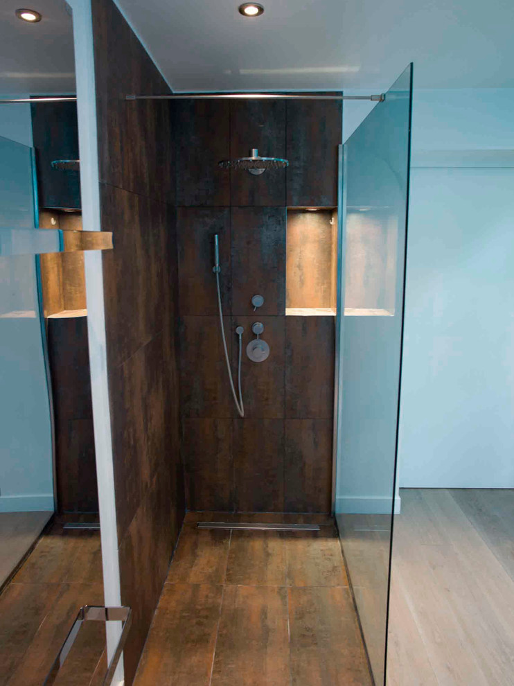 Cette image montre une très grande salle de bain principale design en bois foncé avec un placard sans porte, une baignoire indépendante, une douche d'angle, un mur blanc, un sol en bois brun, une vasque et un plan de toilette en bois.