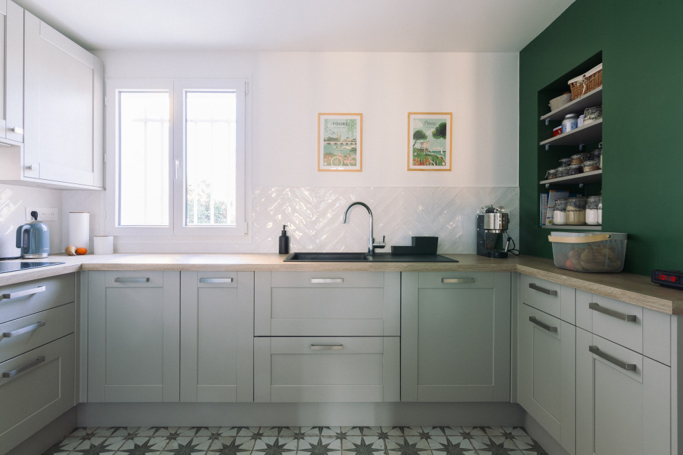 Design ideas for a medium sized country u-shaped enclosed kitchen in Paris with recessed-panel cabinets, green cabinets, wood worktops, white splashback, metro tiled splashback, cement flooring, no island, multi-coloured floors and beige worktops.