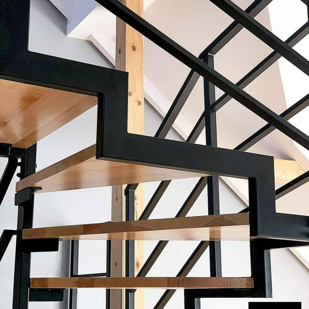 Foto de escalera de caracol industrial de tamaño medio con escalones de madera, contrahuellas de madera y barandilla de metal