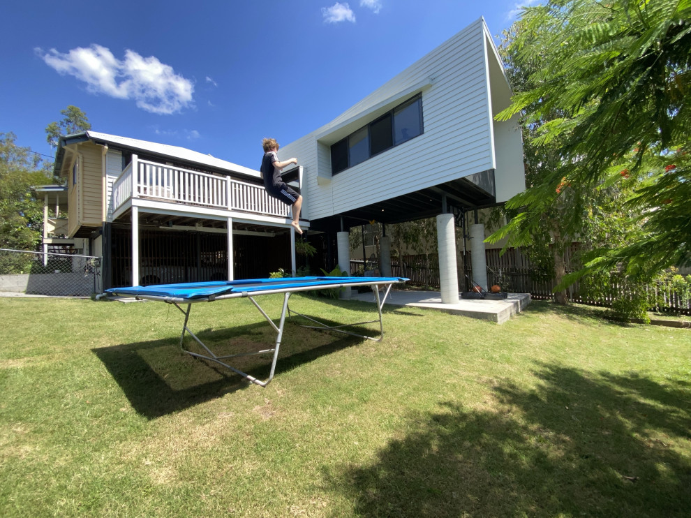 Kleines, Zweistöckiges Modernes Einfamilienhaus mit Faserzement-Fassade, weißer Fassadenfarbe, Walmdach, Blechdach, weißem Dach und Verschalung in Brisbane