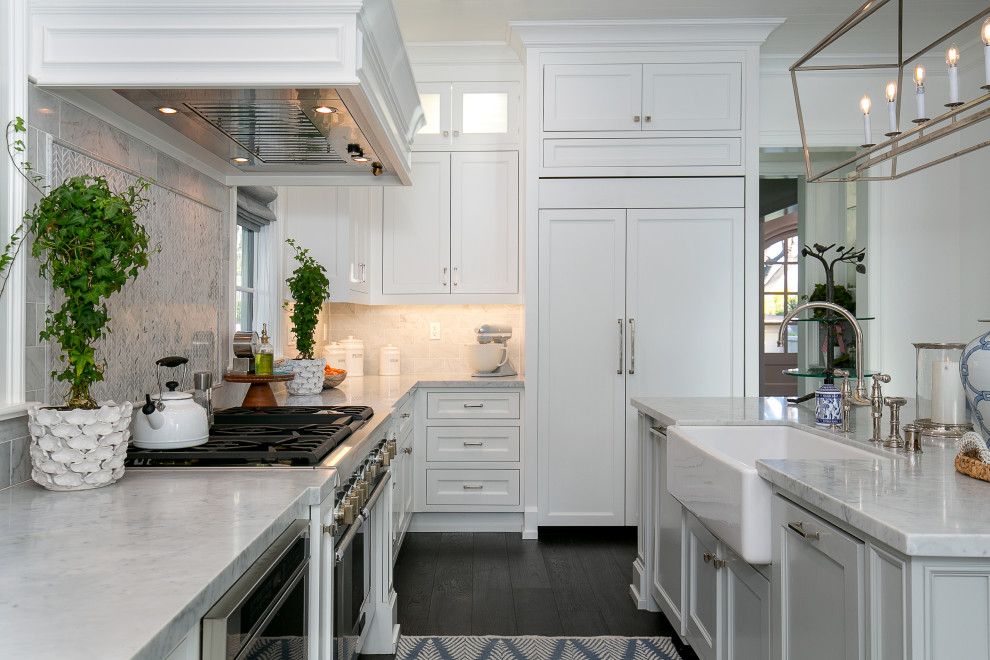 Design ideas for a transitional kitchen in Los Angeles with a farmhouse sink, shaker cabinets, white cabinets, marble benchtops, multi-coloured splashback, marble splashback, panelled appliances, dark hardwood floors, with island, brown floor, grey benchtop and timber.