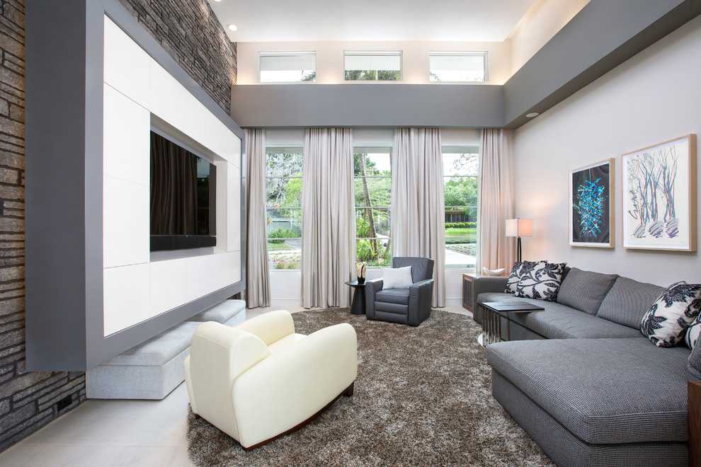 Example of a trendy family room design in Orlando with white walls and a media wall