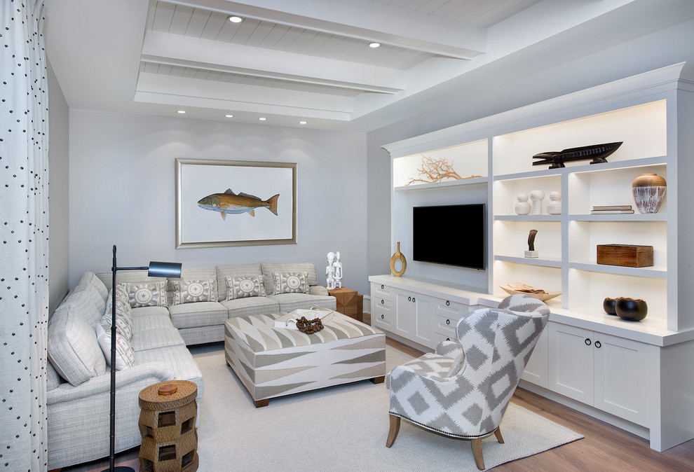Beach style family room in Cleveland with grey walls, light hardwood floors and a built-in media wall.