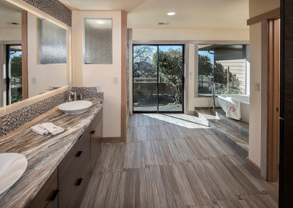 This is an example of a large contemporary master bathroom in Sacramento with flat-panel cabinets, dark wood cabinets, a freestanding tub, an alcove shower, blue tile, multi-coloured tile, white tile, mosaic tile, beige walls, porcelain floors, a vessel sink and quartzite benchtops.