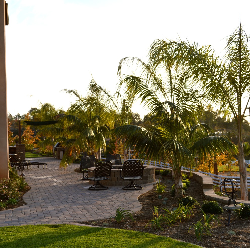 Large mediterranean side yard partial sun garden in San Diego with a fire feature and concrete pavers for fall.